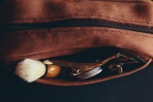 Leather Dopp kit with shaving brush and razor for a Dopp kit materials comparison guide